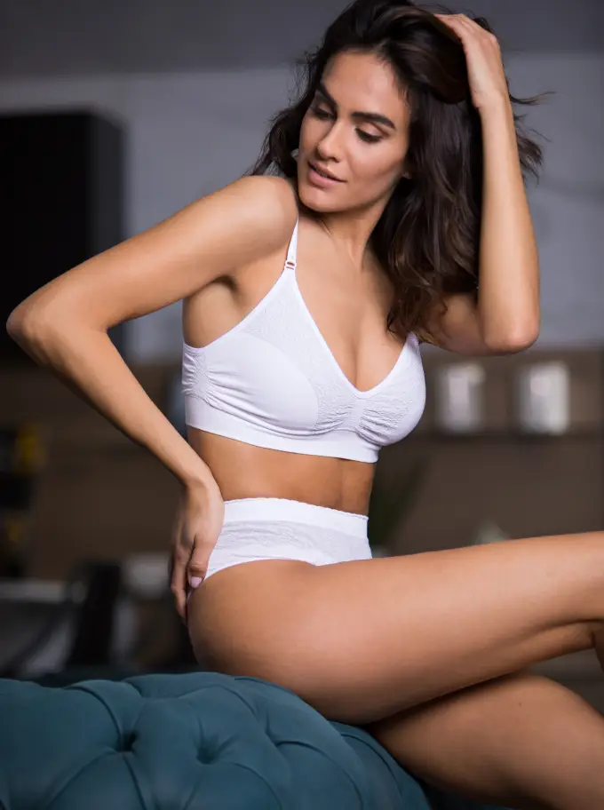 A woman wearing a white Intimidea lingerie set decorated with Jacquard lace